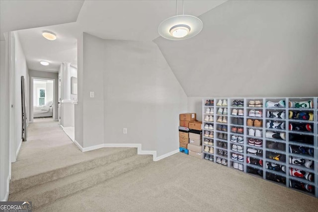 bonus room with light colored carpet and vaulted ceiling