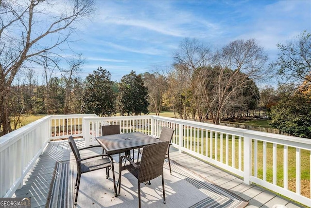 wooden deck featuring a lawn