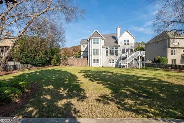 rear view of property with a deck and a yard