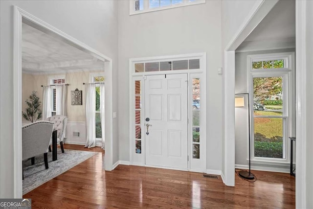 entrance foyer with ornamental molding and hardwood / wood-style flooring