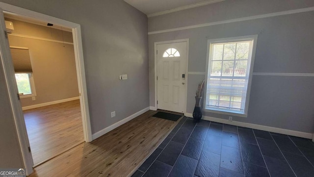 foyer entrance with crown molding and dark hardwood / wood-style flooring