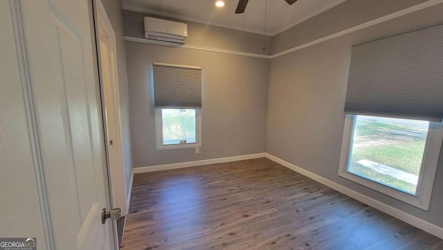 unfurnished room featuring hardwood / wood-style flooring, a wall unit AC, and ceiling fan