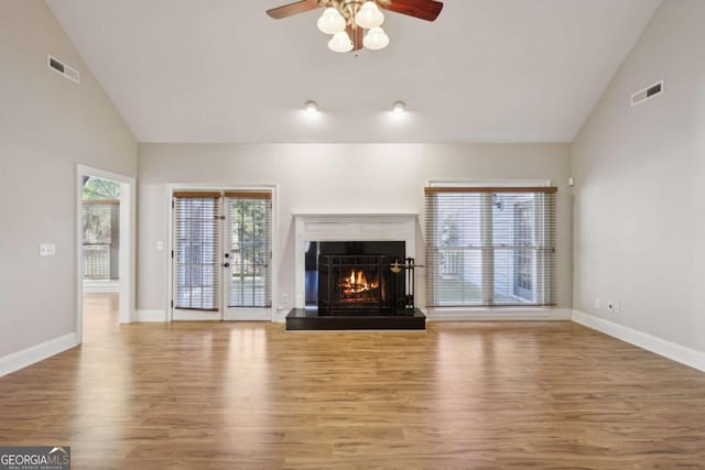 unfurnished living room with hardwood / wood-style floors, high vaulted ceiling, and ceiling fan