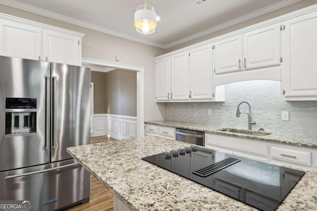 kitchen with pendant lighting, white cabinets, sink, light stone counters, and stainless steel appliances