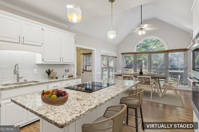 kitchen featuring white cabinets, black electric cooktop, hanging light fixtures, and ceiling fan