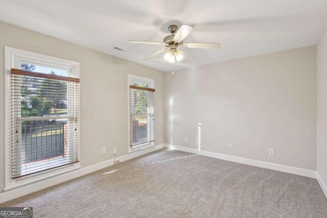 carpeted spare room featuring ceiling fan