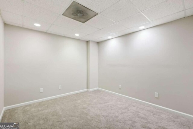 unfurnished room with a paneled ceiling and light carpet