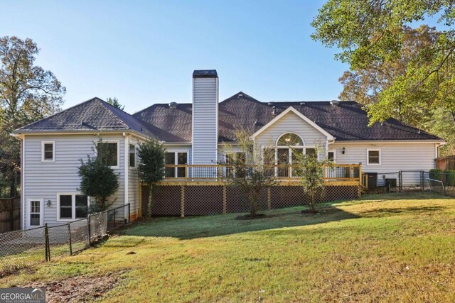 rear view of house with a yard and a wooden deck