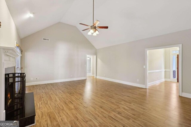 unfurnished living room featuring light wood-type flooring, high vaulted ceiling, and ceiling fan