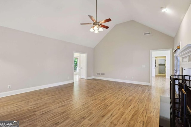 unfurnished living room featuring ceiling fan, high vaulted ceiling, and light wood-type flooring