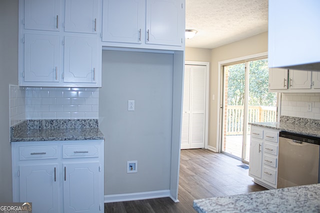 kitchen with white cabinets, dishwasher, and dark stone counters