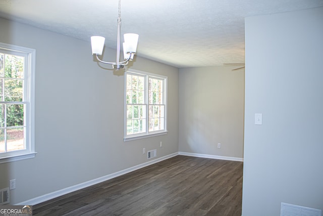 unfurnished room featuring a textured ceiling, ceiling fan with notable chandelier, and dark hardwood / wood-style floors