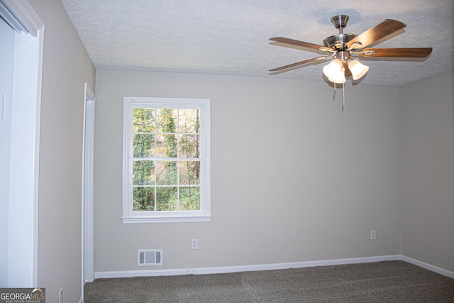 carpeted spare room featuring ceiling fan and a textured ceiling