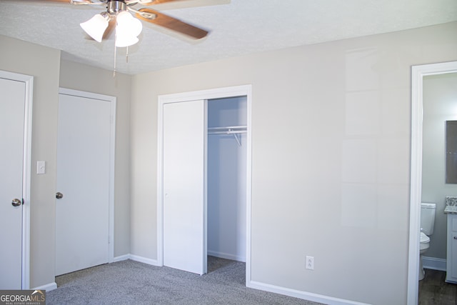 unfurnished bedroom featuring carpet, a textured ceiling, connected bathroom, and ceiling fan