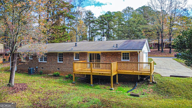 rear view of property with central air condition unit, a wooden deck, and a yard