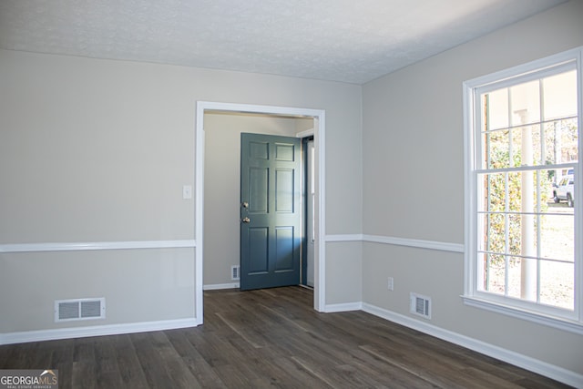 spare room with dark wood-type flooring and a textured ceiling