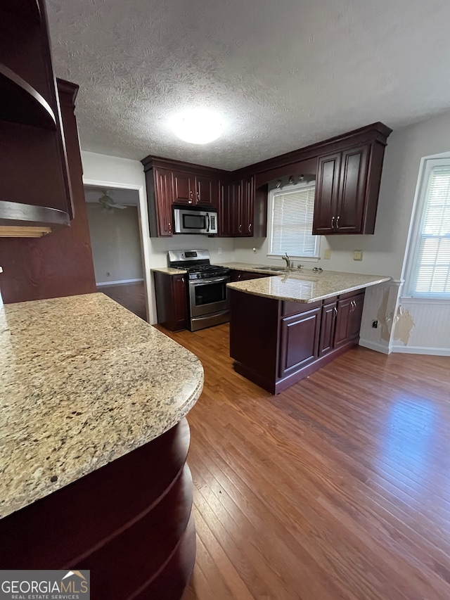 kitchen featuring a textured ceiling, sink, wood-type flooring, and stainless steel appliances