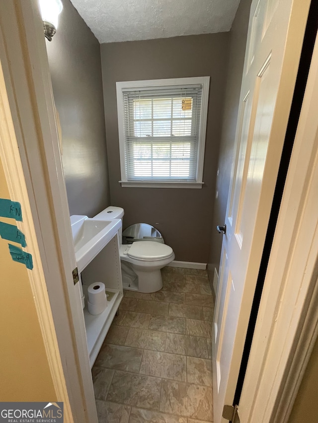 bathroom featuring a textured ceiling and toilet