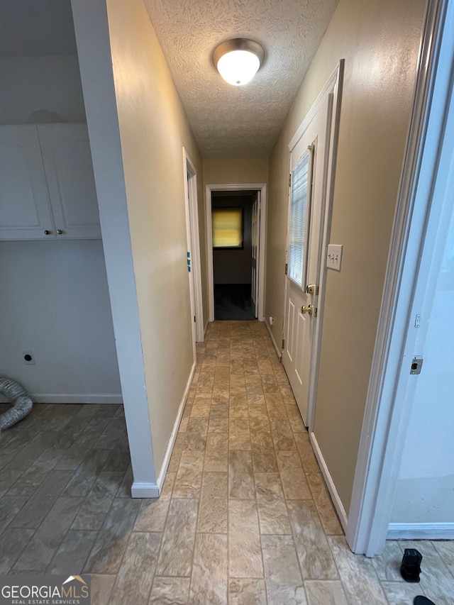 hallway with a textured ceiling