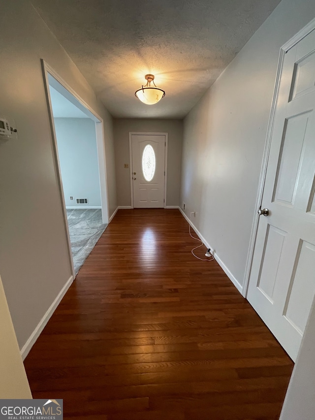 entryway with a textured ceiling and dark hardwood / wood-style floors