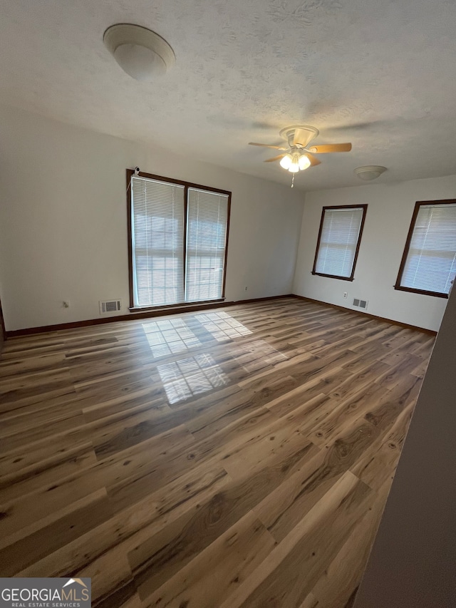 spare room featuring a textured ceiling, dark hardwood / wood-style flooring, and ceiling fan