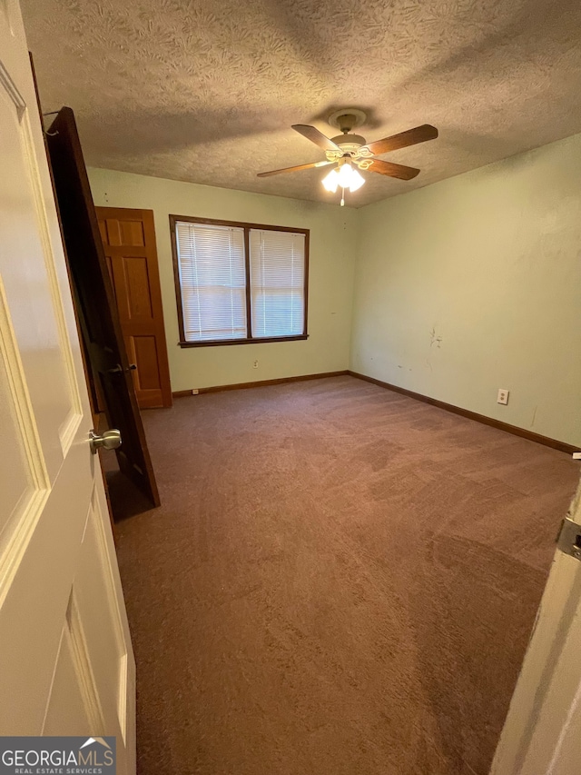 carpeted spare room with a textured ceiling and ceiling fan