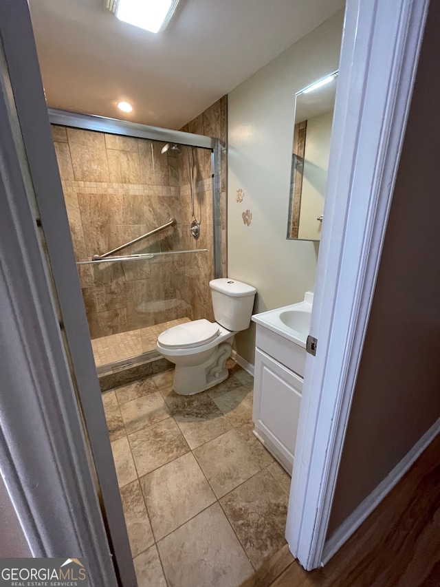 bathroom featuring vanity, toilet, and walk in shower