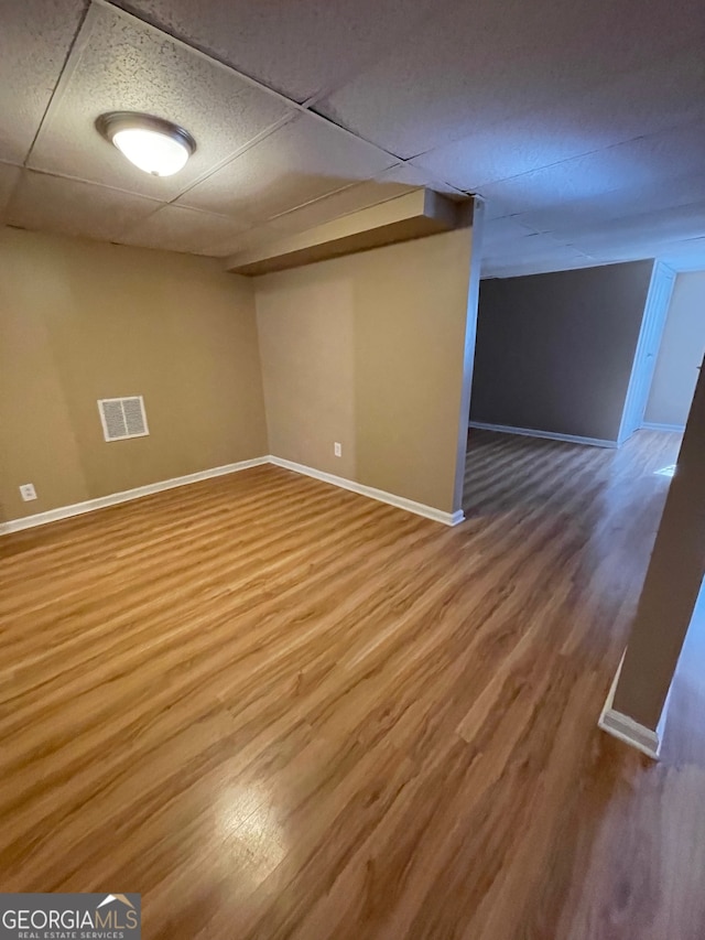 basement featuring hardwood / wood-style floors and a drop ceiling