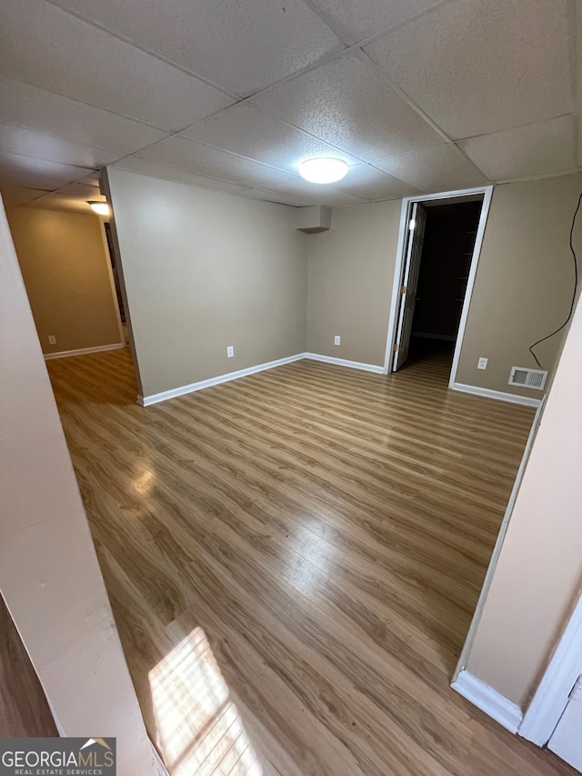 empty room featuring hardwood / wood-style floors and a paneled ceiling