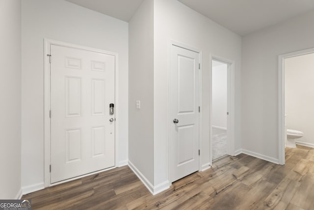 entrance foyer with baseboards and wood finished floors