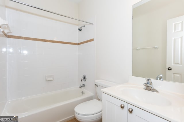 full bathroom with vanity, tiled shower / bath, and toilet