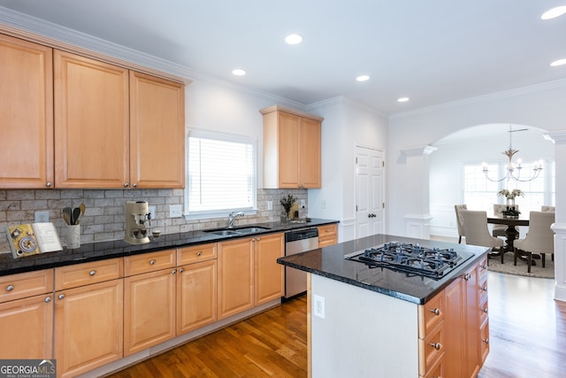 kitchen featuring pendant lighting, sink, light hardwood / wood-style flooring, appliances with stainless steel finishes, and a center island