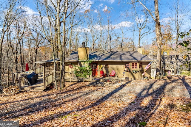 back of house featuring a sunroom and a wooden deck