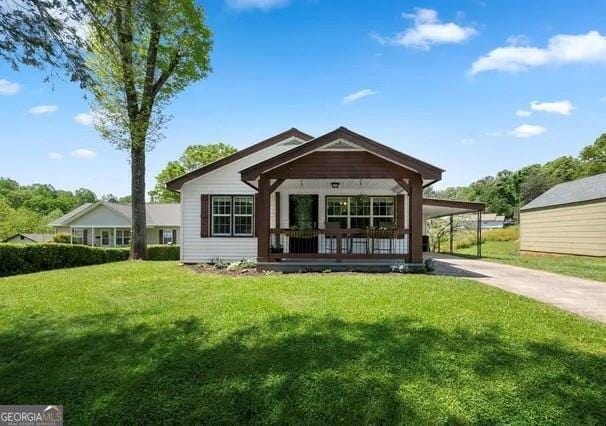 rear view of house featuring a yard, a porch, and a carport