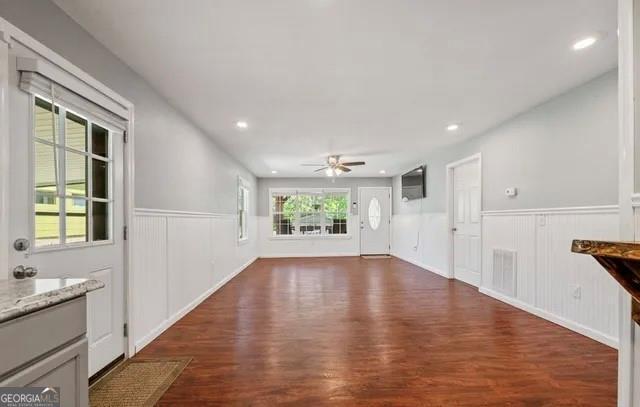 unfurnished living room featuring dark hardwood / wood-style floors and ceiling fan