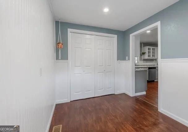 unfurnished bedroom featuring a closet and dark hardwood / wood-style flooring