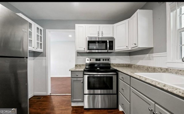 kitchen with white cabinetry, dark wood-type flooring, stainless steel appliances, and sink