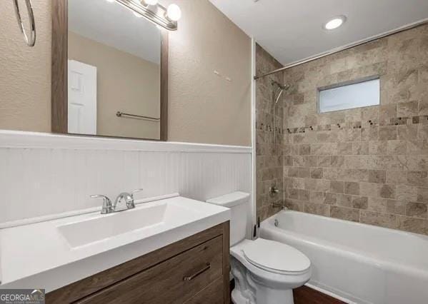 full bathroom with vanity, toilet, and tiled shower / bath