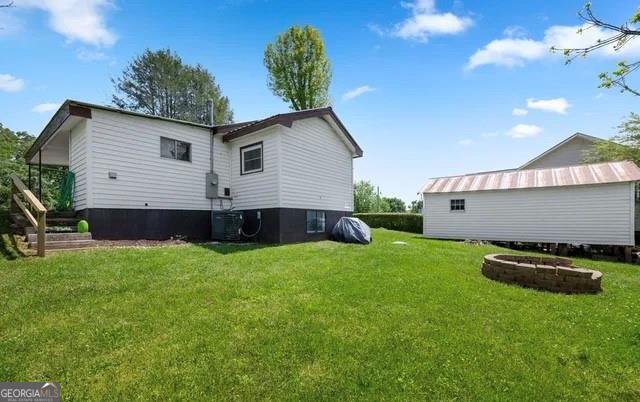 rear view of property featuring a lawn