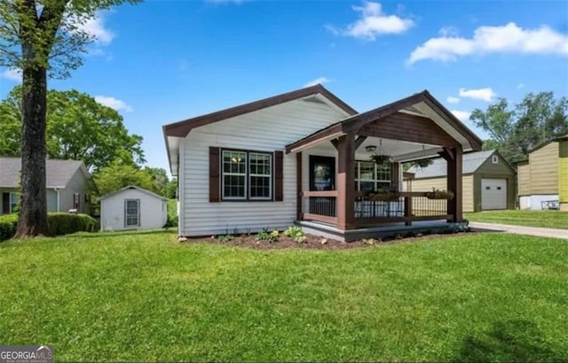 view of front of home featuring covered porch, a front yard, and a garage