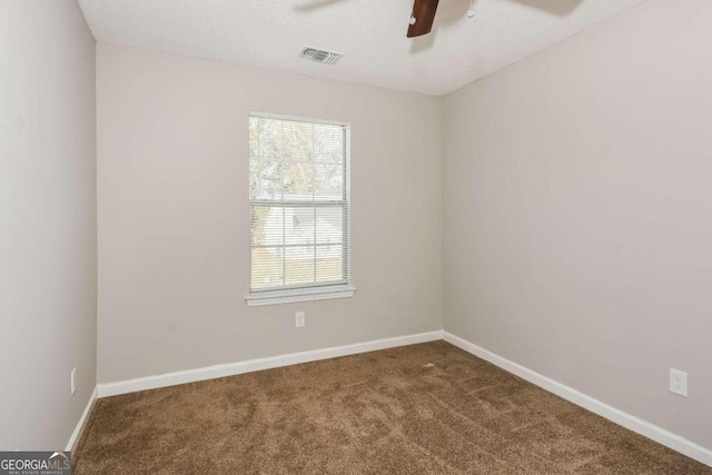 spare room with a textured ceiling, carpet floors, and ceiling fan