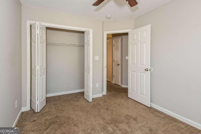 unfurnished bedroom featuring a textured ceiling, carpet floors, a closet, and ceiling fan