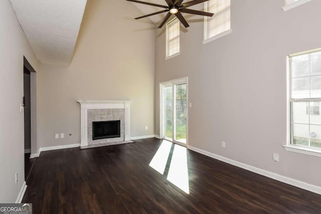 unfurnished living room with a wealth of natural light, dark hardwood / wood-style floors, and a textured ceiling