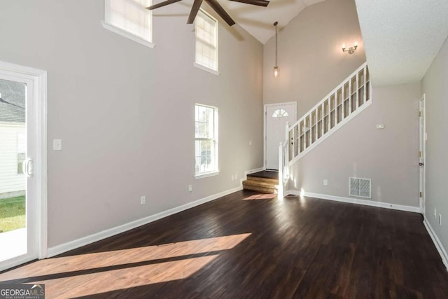 unfurnished living room featuring ceiling fan, high vaulted ceiling, a textured ceiling, and hardwood / wood-style flooring