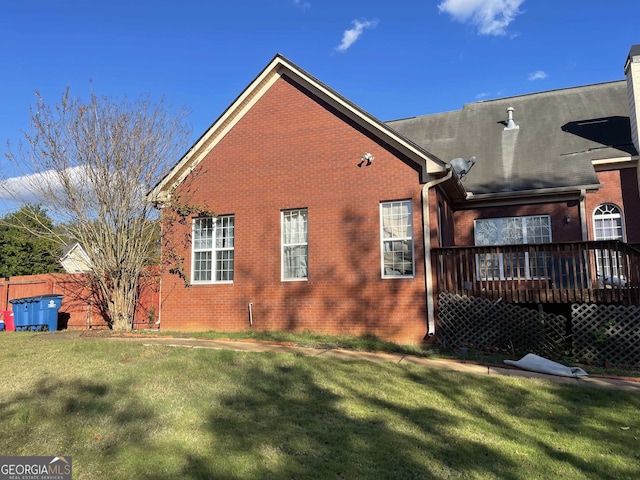 rear view of property with a lawn and a wooden deck