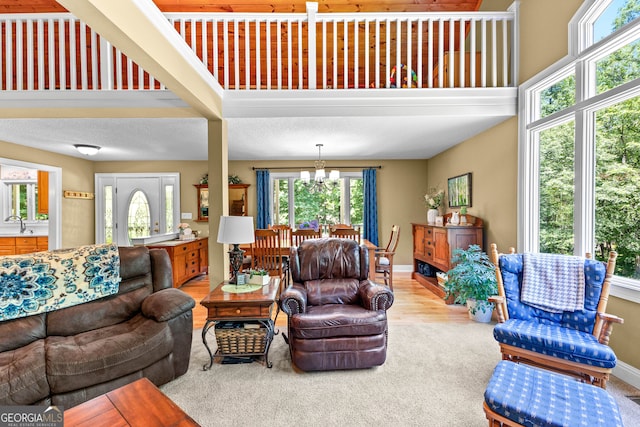 living room with hardwood / wood-style flooring, plenty of natural light, sink, and a chandelier