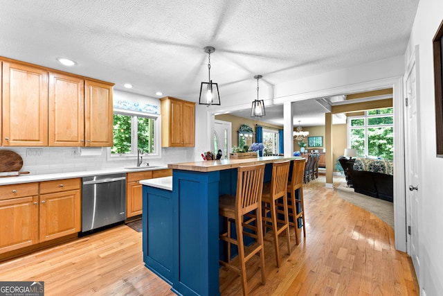 kitchen with dishwasher, pendant lighting, light hardwood / wood-style flooring, and a wealth of natural light