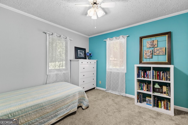 carpeted bedroom with a textured ceiling, ceiling fan, and crown molding