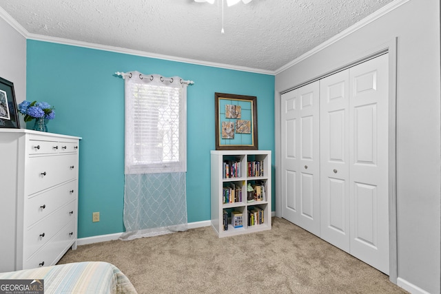 bedroom featuring a textured ceiling, light colored carpet, a closet, and ornamental molding