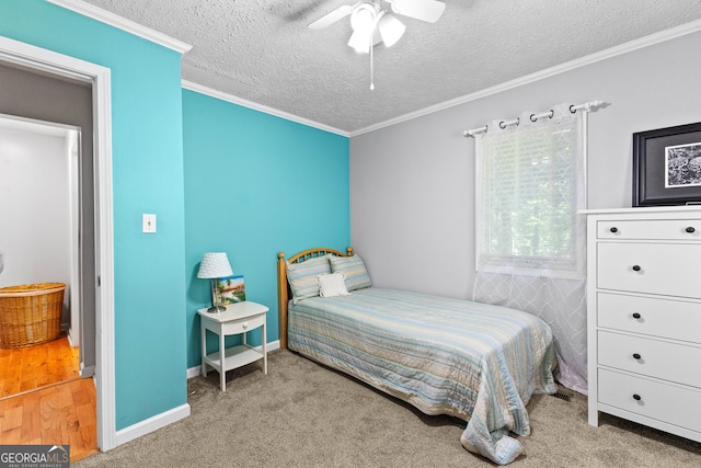 bedroom with carpet flooring, ceiling fan, crown molding, and a textured ceiling